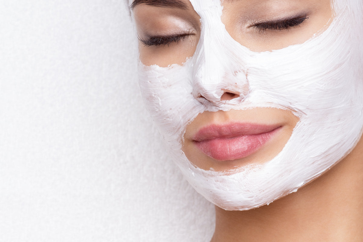 A woman relaxing with a white cream mask on her face