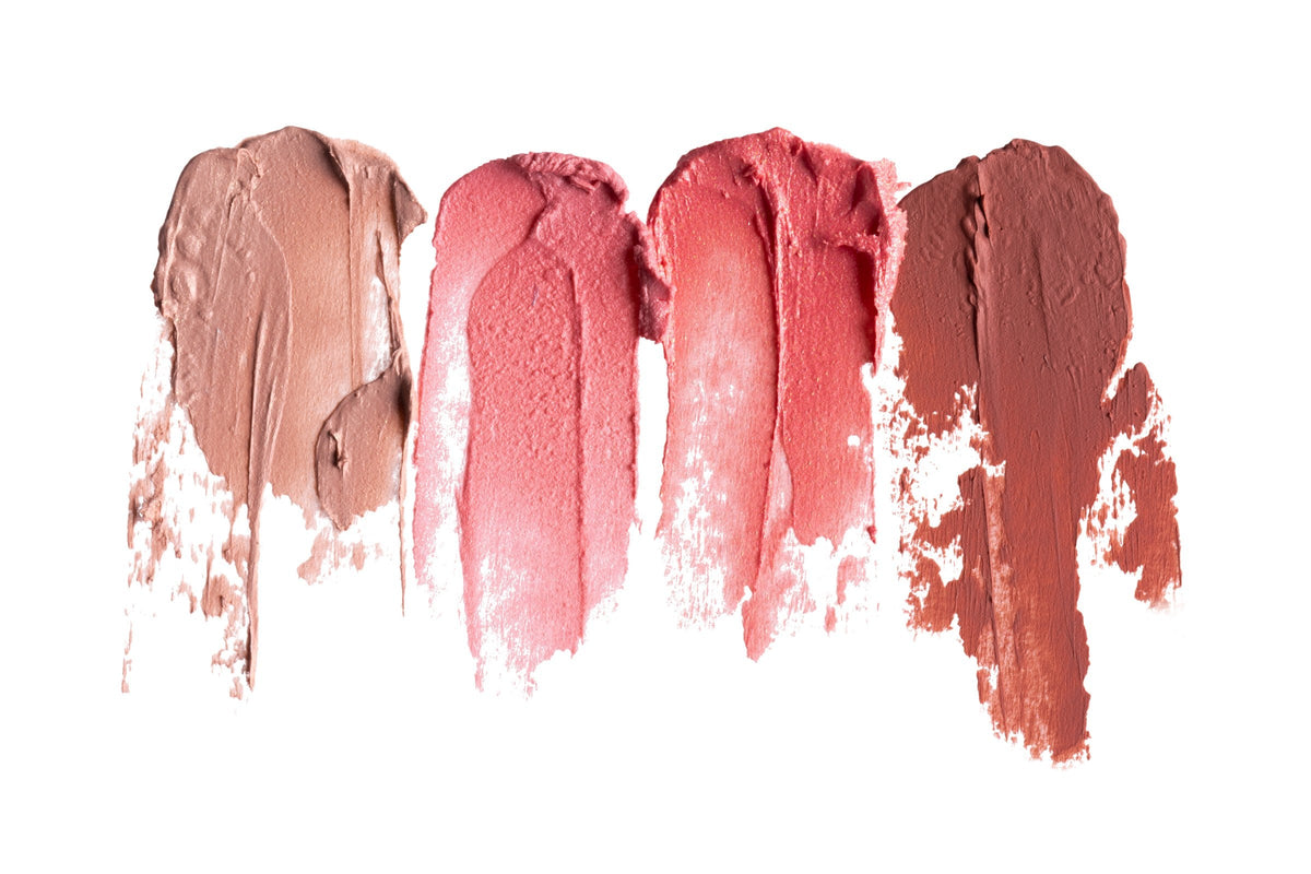 Five lipstick swatches in shades of pink and brown on white