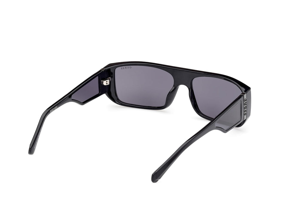 Guess rectangular black plastic sunglasses with thick frame, dark tinted lenses, straight temples, lens logo