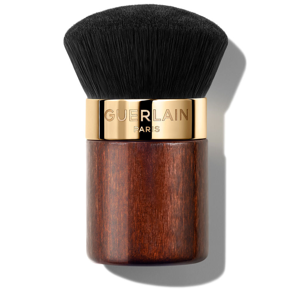 Guerlain Dense rounded kabuki brush with satin mahogany wooden handle, gold metal band, and brown synthetic bristles