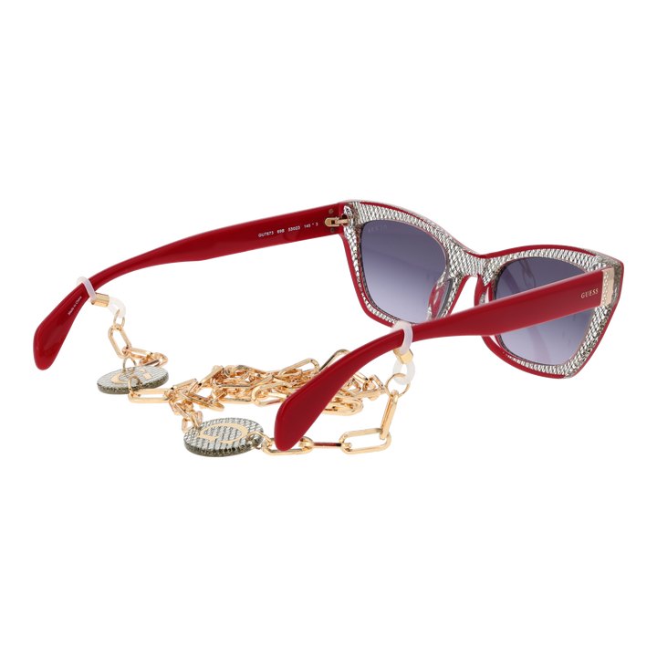 Red and black textured cat-eye sunglasses with gradient grey lenses and decorative gold chain over a neutral background