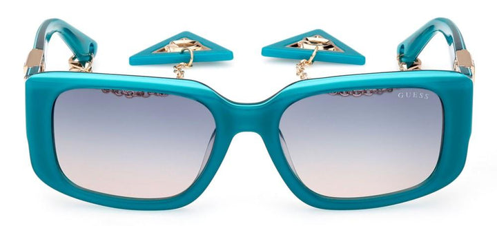 Teal rectangular sunglasses with gradient lenses, gold metal accents and dangling triangular charm chain on temples
