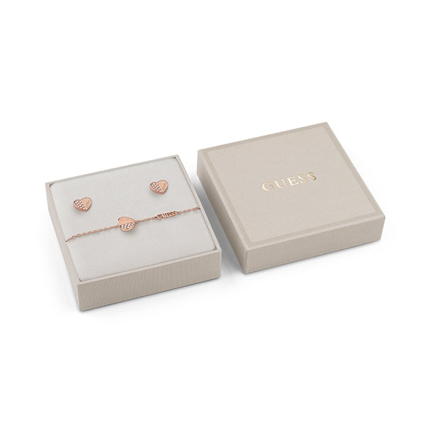 Rose gold heart stud earrings and matching heart charm bracelet with small crystals on beige background