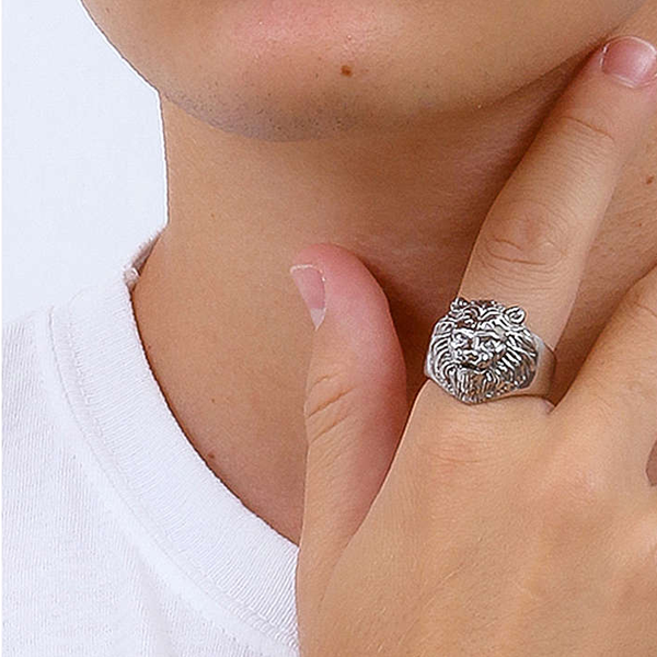 Silver lion head ring on neutral background showing detailed face and textured mane