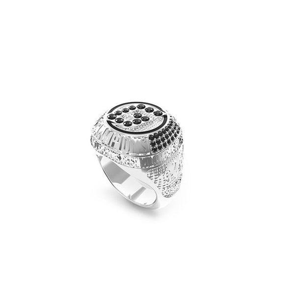 Silver signet ring with round black stones, engraved rim and textured band on neutral background