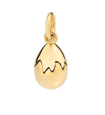 Close-up of polished gold egg-shaped pendant with attached loop on white background, minimalist luxury design